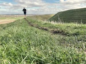 a blurry runner in the distance of an iron age hillfort