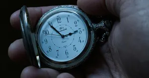 an old antique pocket watch held in the hand