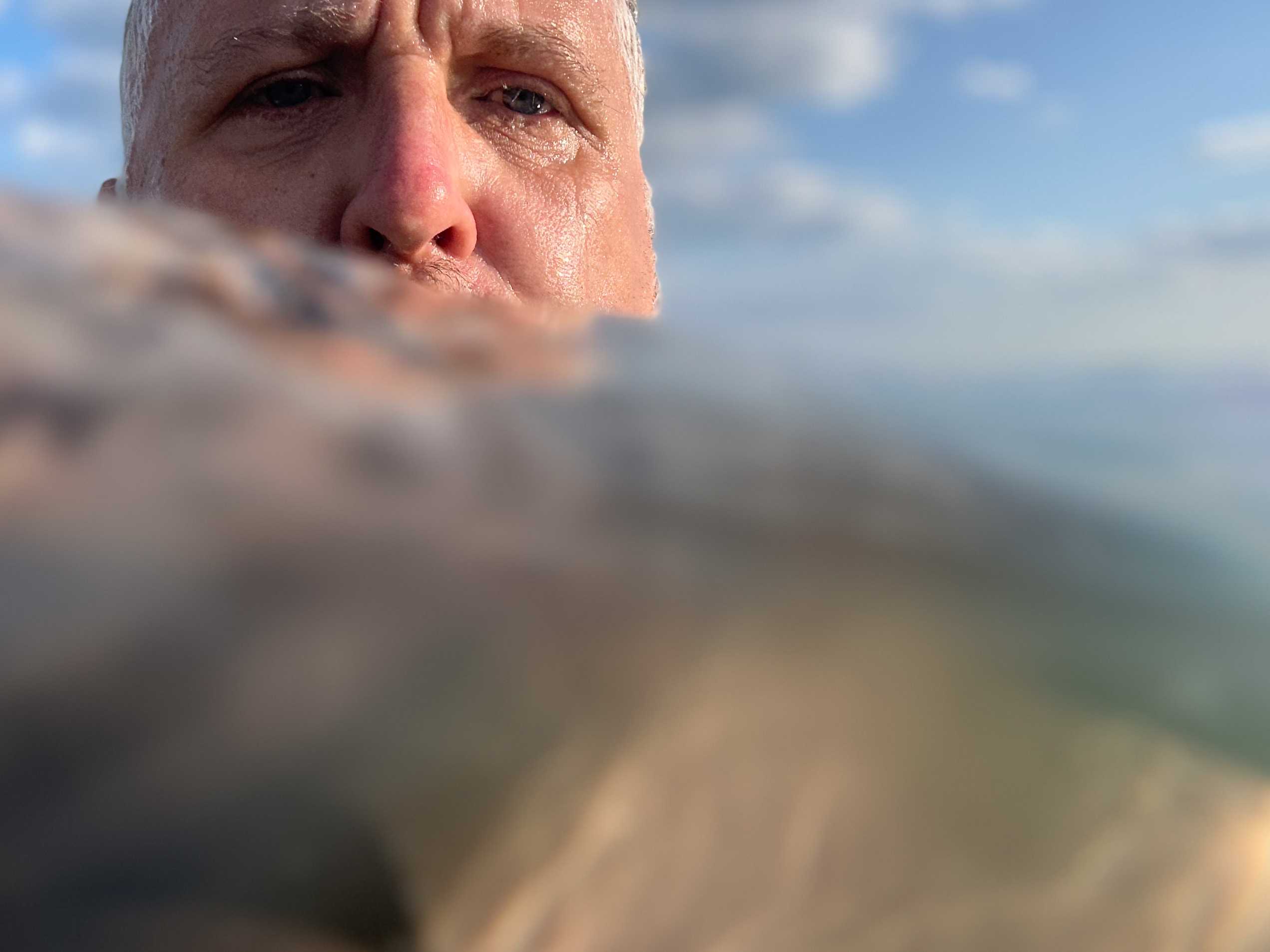 The water/sea fills two thirds of the frame, my head appears over a wave in the top left of the frame, backed by blue sky