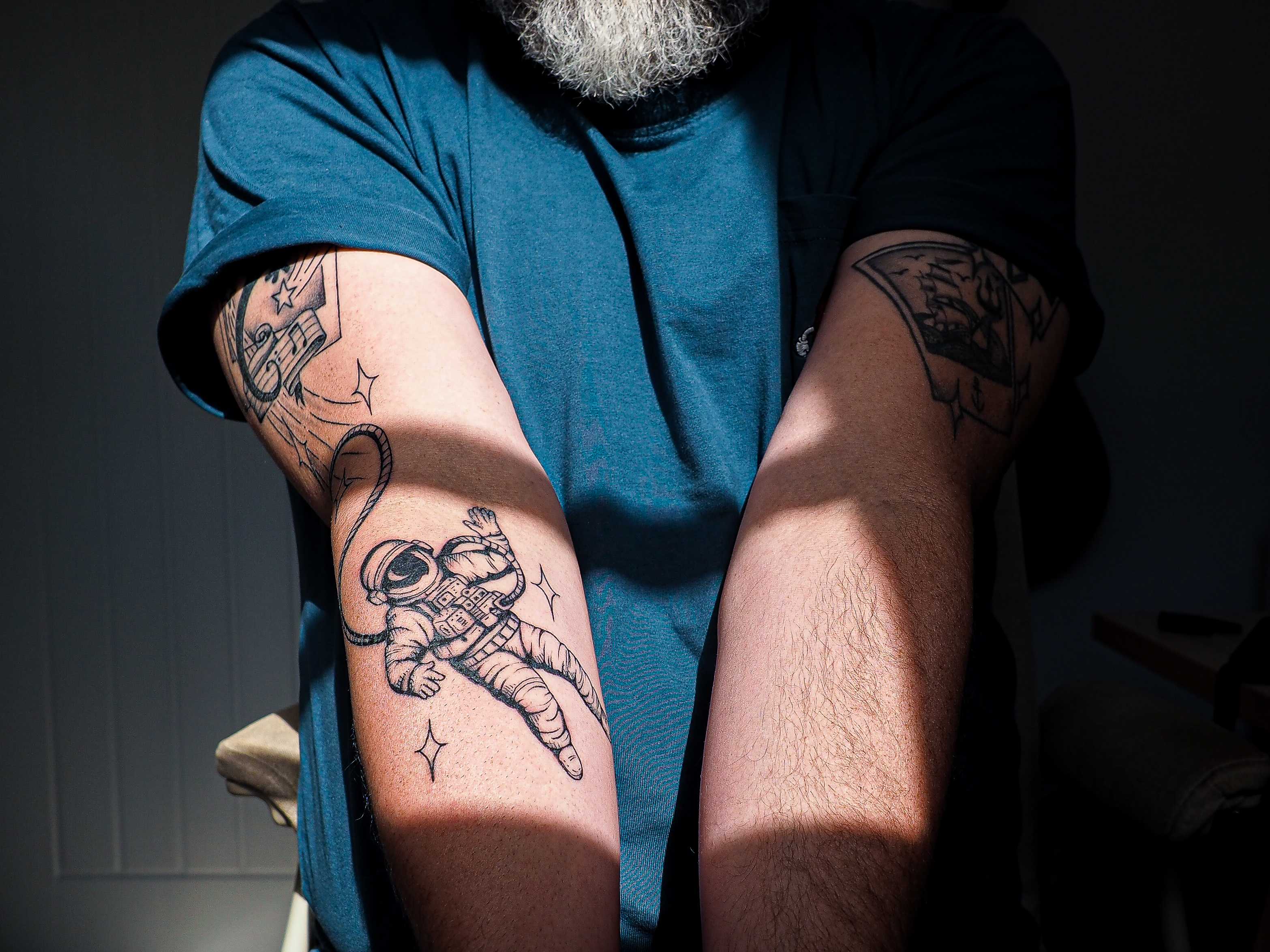 A tightly cropped photo of my arms, showing my tattoos, illuminated by window light